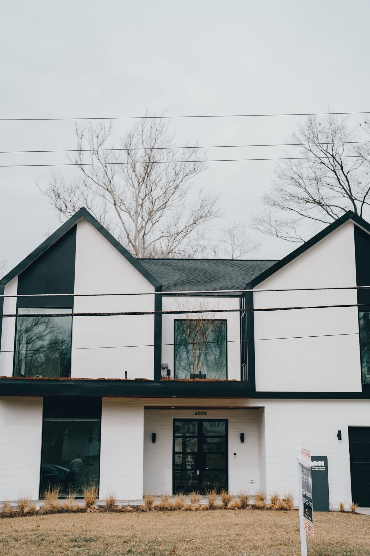 The Longyard — dark and white shed home with a six-bay workshop wing